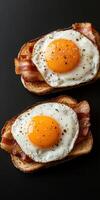 Breakfast toast with fried eggs and crispy bacon on dark background photo