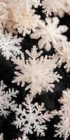 Detailed macro of artificial white snowflake arrangement on black textured background photo