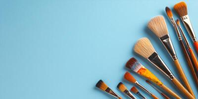 Collection of artist paintbrushes arranged in a fan shape on a blue background photo