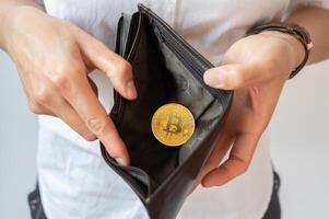 Close up of someone open wallet for showing just one Bitcoin token inside. photo
