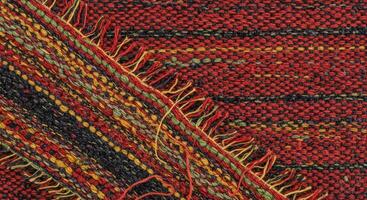 A close up of a red and green woven rug photo