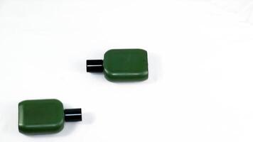 two green bottles sitting on top of each other isolated on white background. photo