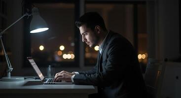 Focused Man Working Late Nighttime Laptop Use Dramatic Lighting photo