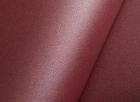 Elegant dark burgundy paper texture with a shimmering, glittering finish and subtly rolled edges. photo