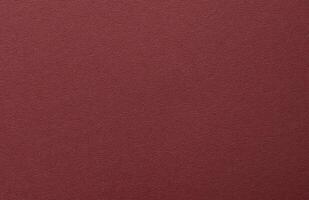 Burgundy paper background with a matte texture and fine, tactile surface. Deep, rich red tones photo