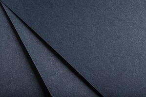 Dark blue paper background with a sleek, glossy texture and a shimmering finish. Elegant, modern photo