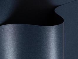 Blue paper background with a smooth, glossy texture and metallic shimmer. Cool, dark tones create an photo