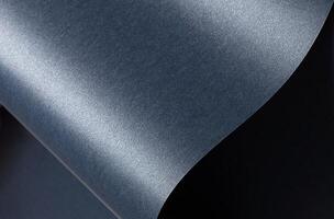 Blue paper background with a smooth, glossy texture and pearlescent finish. Deep, cool tones with a photo