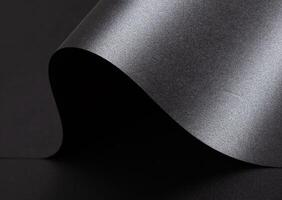 Black paper background with a smooth, glossy texture and metallic, reflective finish. Elegant, photo