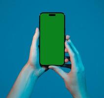 Smartphone held in both hands, displaying blank screen for mockup. Person presenting mobile device photo
