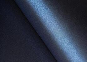 Navy blue paper background with a smooth, pearlescent texture and rolled edges. Deep, dark tones photo