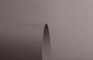 Gray paper background with a matte texture and curved, wavy edges. Neutral taupe and brown tones photo