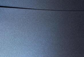 Navy blue paper background with a smooth, glossy texture and pearlescent finish. Deep, geometric photo