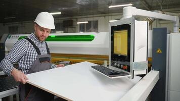 Worker Loads Wood Panel into CNC Cutting Machine video