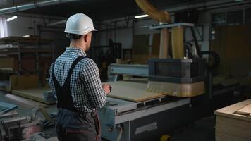 Worker Controls CNC Router Cutting Wooden Panels at Furniture Factory video