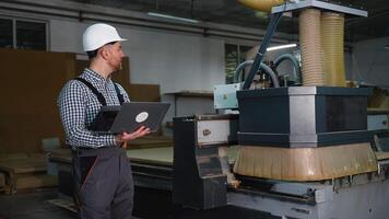 Engineer with Laptop Monitoring CNC Wood Cutting Machine video