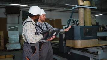 Two Workers Monitor CNC MDF Cutting Machine Operation video