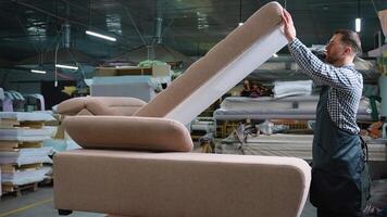 Man Testing Sofa Lift Mechanism in Furniture Workshop video