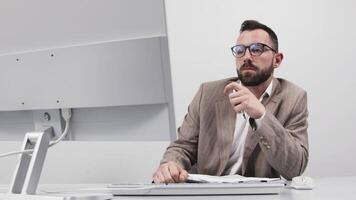 Unhappy young Caucasian male worker in glasses look at pc computer screen thinking about operational problems. Frustrated man confused surprised by unexpected error on computer device video