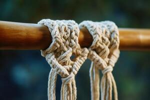 Two pieces of string are tied together on a wooden pole photo