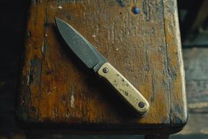 A knife is sitting on a wooden table photo