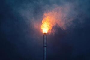 A tall, silver pole with a flame on top photo