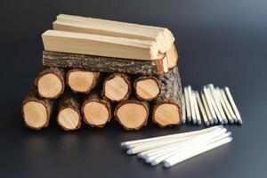 A pile of wood logs and matches on a table photo