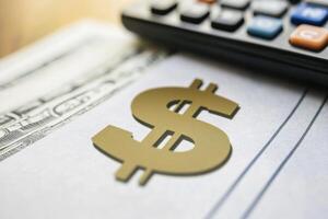 A calculator sits on top of a check with a dollar sign on it photo