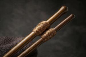 Two wooden chopsticks with a brown string wrapped around them photo