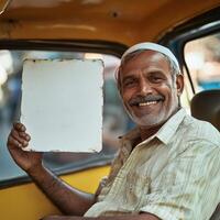 A man is holding a white sign in a taxi photo