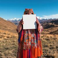A woman in a colorful outfit is holding a white sign photo