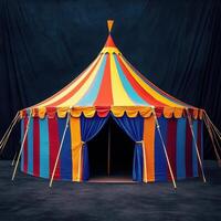 A large circus tent with a red, yellow, and blue striped top photo