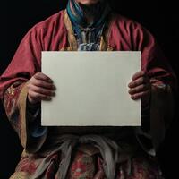 A man in a red robe holding a blank piece of paper photo