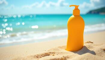 A sunscreen bottle stands on a sandy beach with turquoise waves and a clear sky in the background. photo