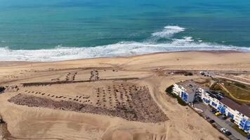 Drone flying over Beach. Showing dune restoration and shoreline in warm light video
