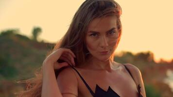 beautiful tall girl stands beach during sunrise soft sunlight illuminating her features and creating serene atmosphere ocean waves gently lap shore video