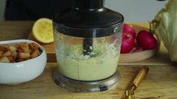 In a blender, the chef combines avocado with other ingredients to create a smooth and healthy Mexican guacamole sauce, rich in vitamins. video