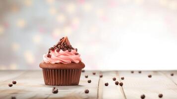 Chocolate cupcake with pink frosting on wooden table with blurred background photo