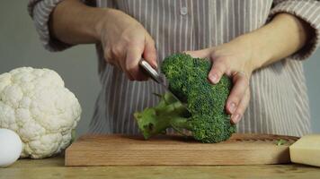 Before making salads, the chef removes unnecessary parts of the broccoli with a knife. Close up. video