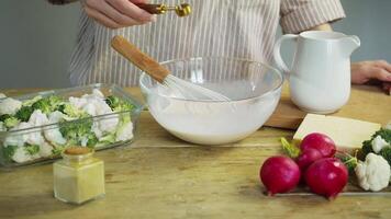 Using a measuring spoon, the chef carefully adds the correct amount of salt to the vegetables in the sauce. video