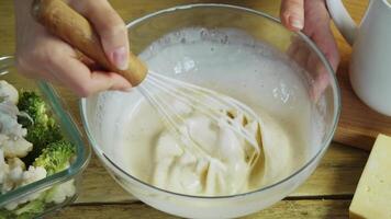 Yogurt and mayo are mixed together in a big bowl until they're creamy, then they're used to make a delicious, rustic veggie dish. Top view. video