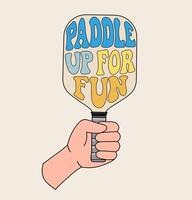 Hand holding a pickleball paddle with Paddle Up For Fun in retro-style lettering, featuring bold colors and vintage aesthetics vector