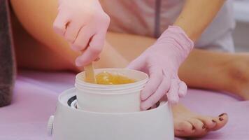 Liquid sugar for skin epilation. Close up shot. depilation and beauty concept - sugar paste or wax honey for hair removing with wooden waxing spatula sticks 11 video