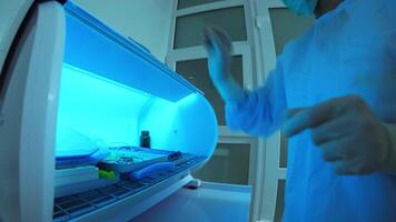 Sterilizing medical instruments in autoclave. Assistant's hands get out sterilizing medical instruments from autoclave. Fisheye. Sterile tools video