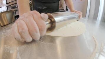 Italian pizza chef forming the dough on a floured surface and rolling out a dough 3 video