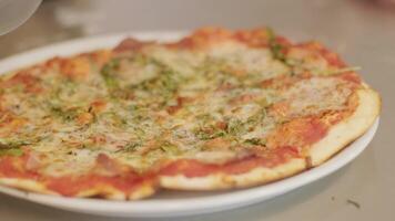 Slow motion close-up of a person slicing pizza into multiple slices with a pizza cutter video