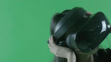 Young beautiful listen music and dancing in the VR headset. Virtual reality helmet on the green background. Chroma Key video