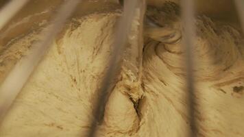 Close-up of dough mixing in a professional kneader machine in kitchen of bakery or at the manufacturing. Stock footage. Dough making process video