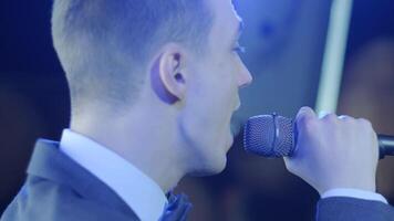 Man singing song in microphone during performance on stage on rock concert. Close up man rock star singer on music concert on colorful light background 8 video