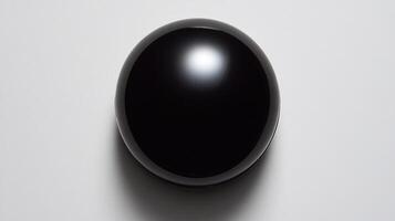 A perfectly smooth, black sphere on a white background, reflecting light photo